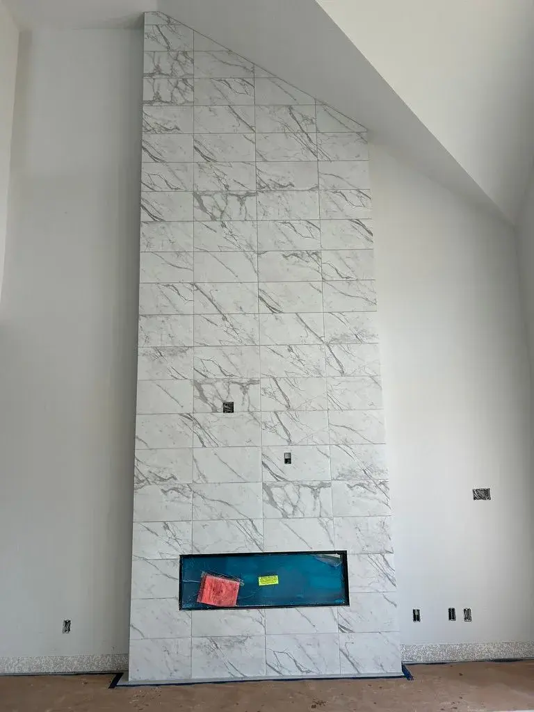 Floor-to-ceiling marble fireplace after remodel by YG Reno