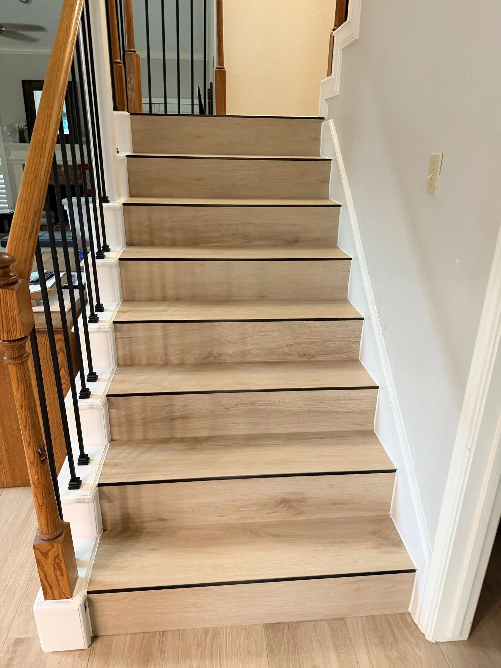 Painted stairs to oak treads and iron balusters after remodel by YG Reno